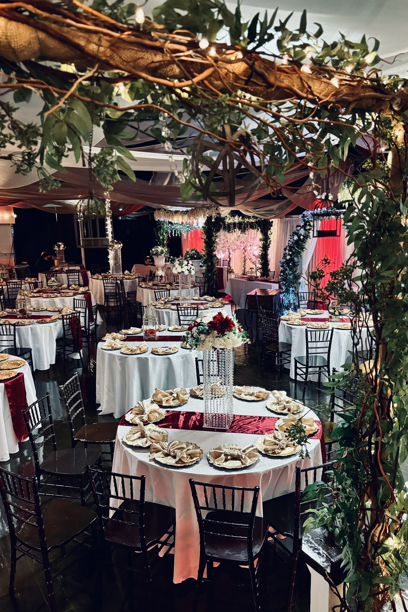 Decorated room at a corporate event with tall centerpieces and decorative lighting
